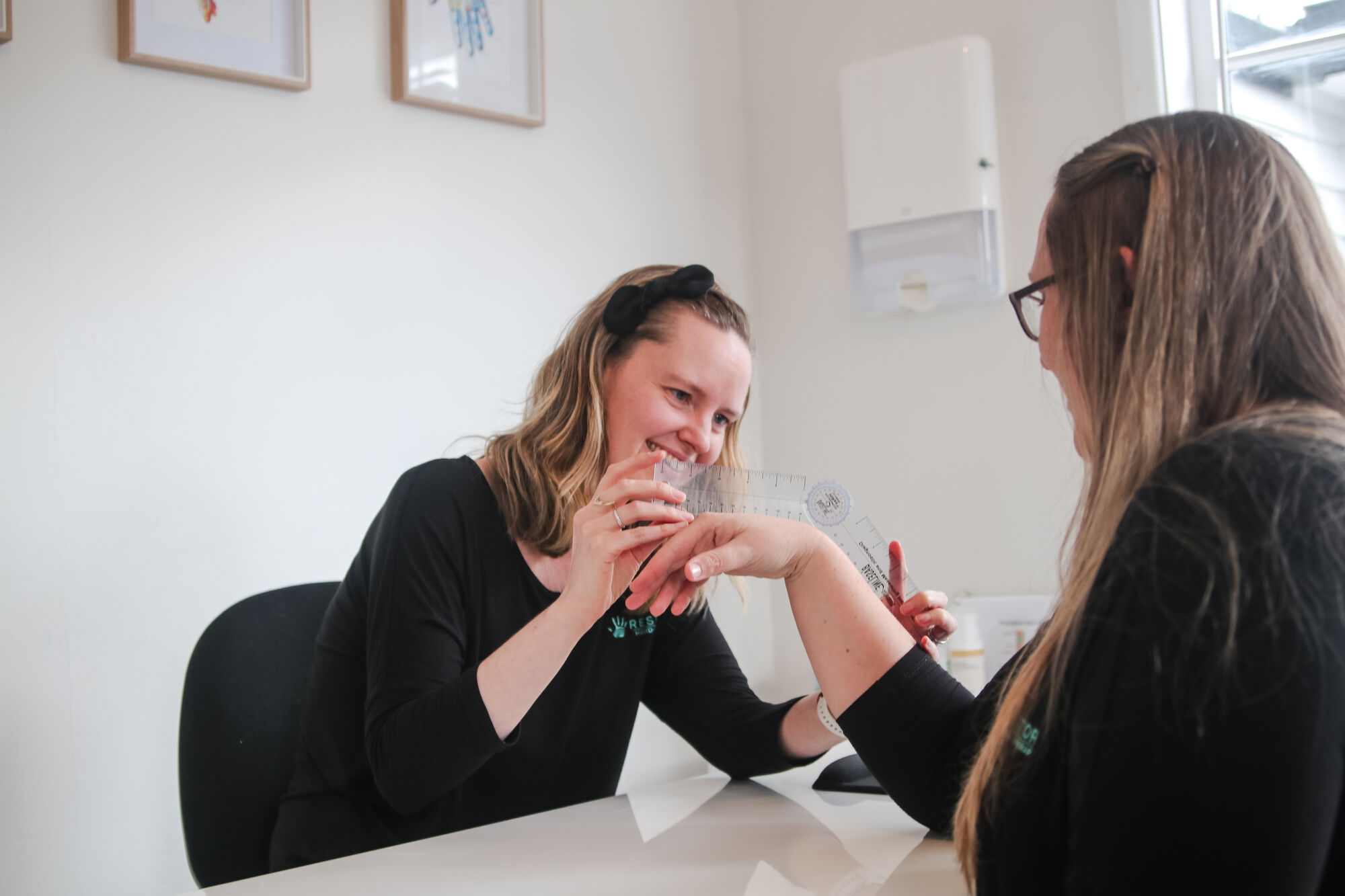 A Restore therapist guiding a patient through a hand exercise