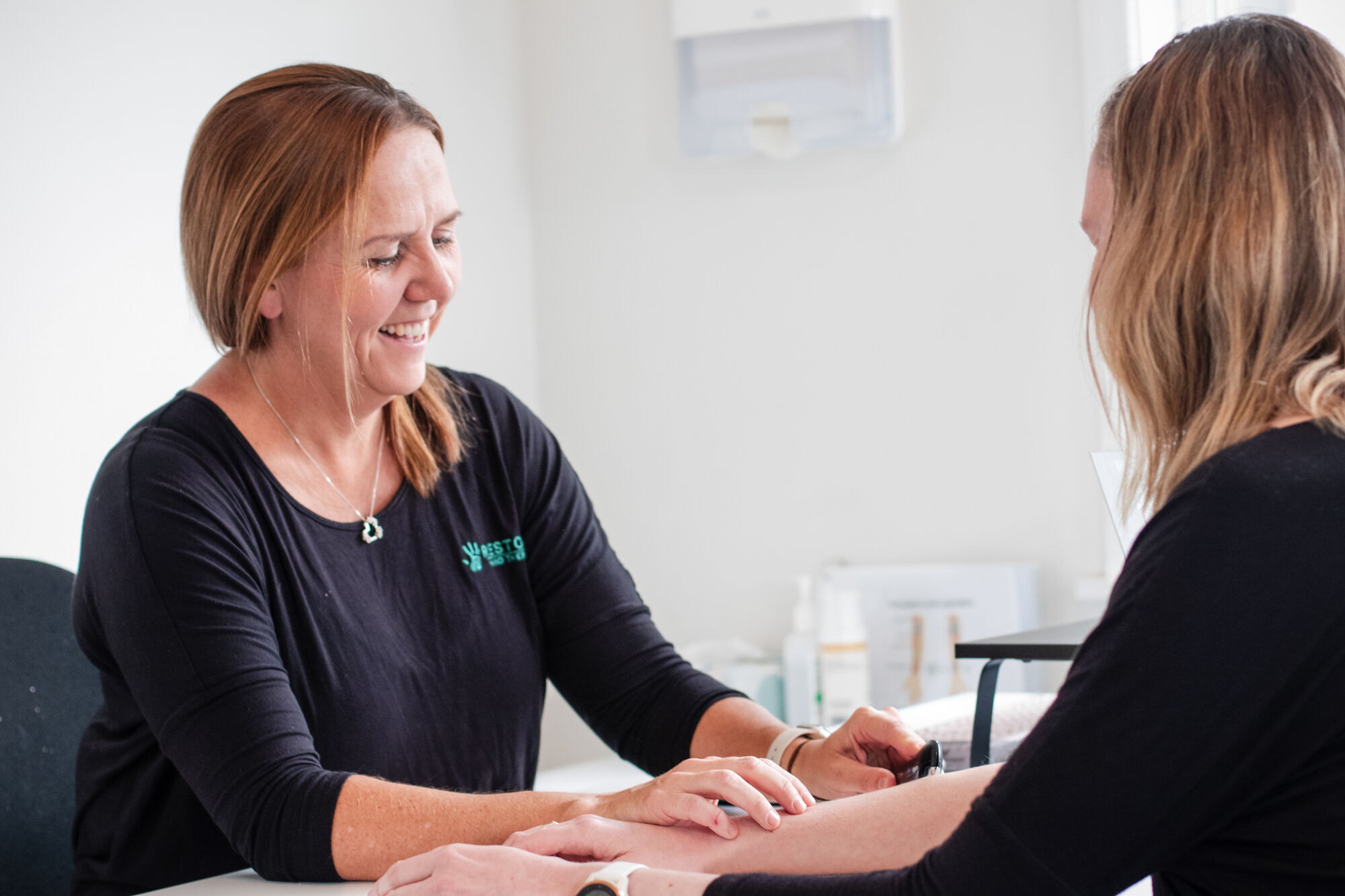 A Restore therapist assessing a patient's wrist movement with a goniometer